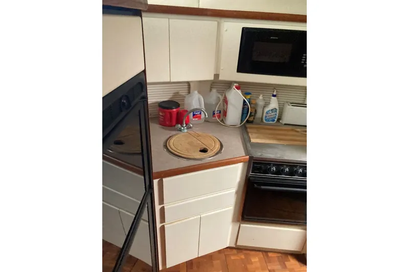 Slide: The Image of 1996 Carver 355 Aft Cabin Motor Yacht kitchen with stove, sink, and microwave. - 17