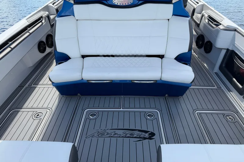 Slide: The Image of 2020 Nor-Tech boat interior with white seating and gray deck flooring. - 16