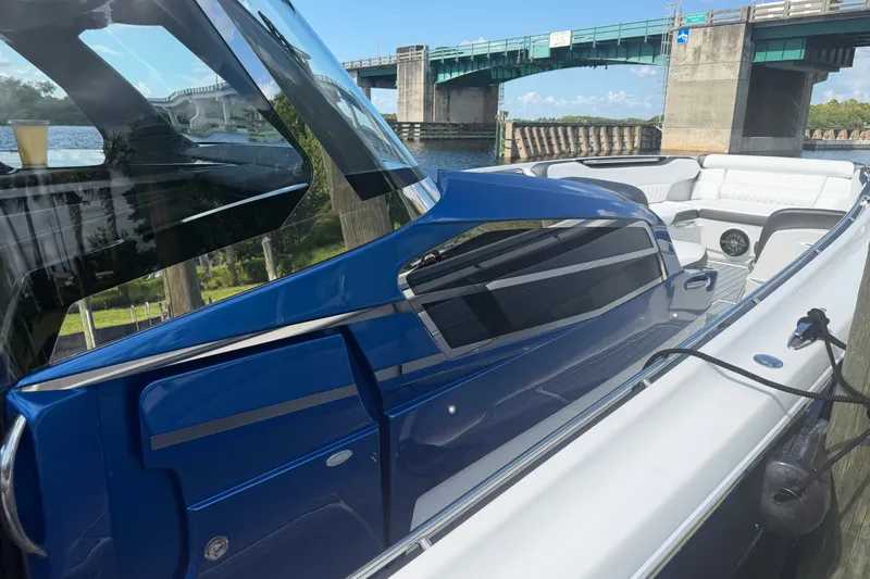 Slide: The Image of 2020 Nor-Tech boat with sleek blue design, docked near a bridge on a sunny day. - 37