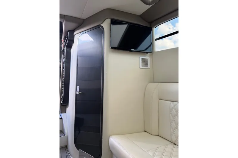 Slide: The Image of Interior of a 2020 Nor-Tech boat featuring a sleek door, TV, and plush seating. - 25
