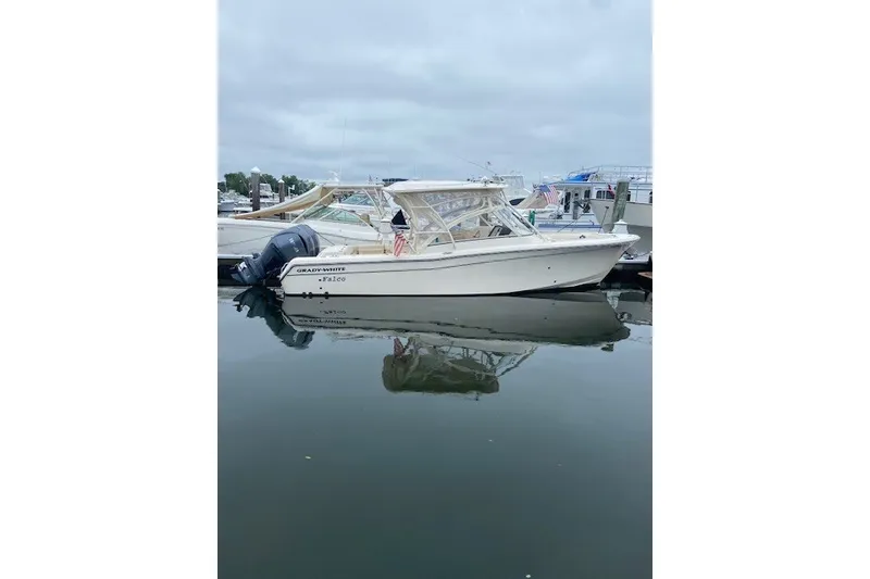 The Image of 2022 Grady-White Freedom 285 boat docked in a marina, reflecting on calm water. - 0