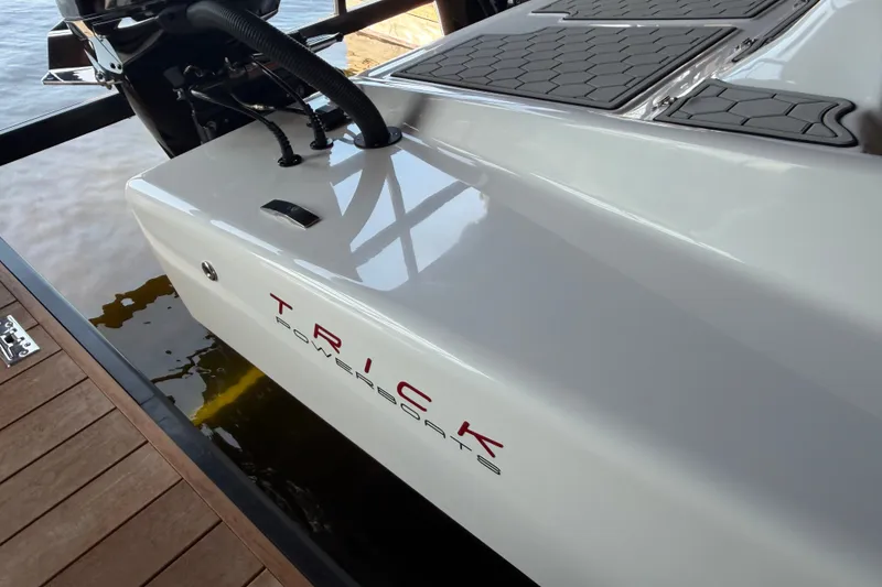 Slide: The Image of 2024 Trick 23 Widebody boat on water, showcasing sleek design and branding. - 7