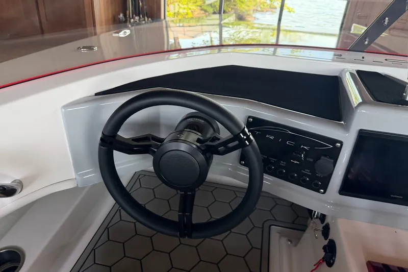 Slide: The Image of Steering wheel and dashboard of 2024 Trick 23 Widebody boat, featuring modern controls. - 13