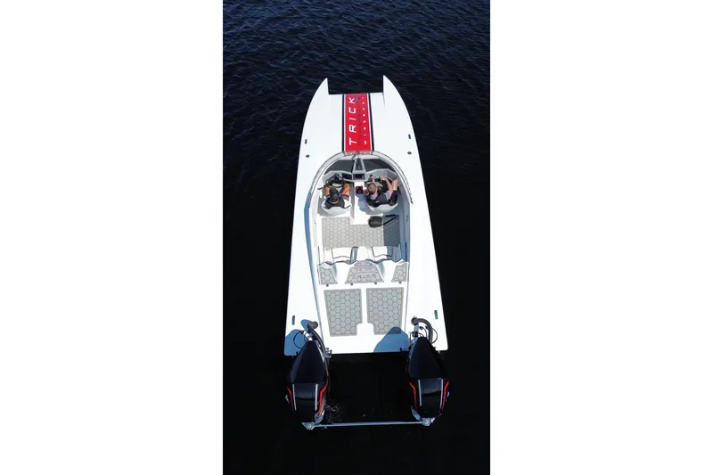 Slide: The Image of 2024 Trick 23 Widebody boat on water, aerial view, showcasing sleek design and dual engines. - 3