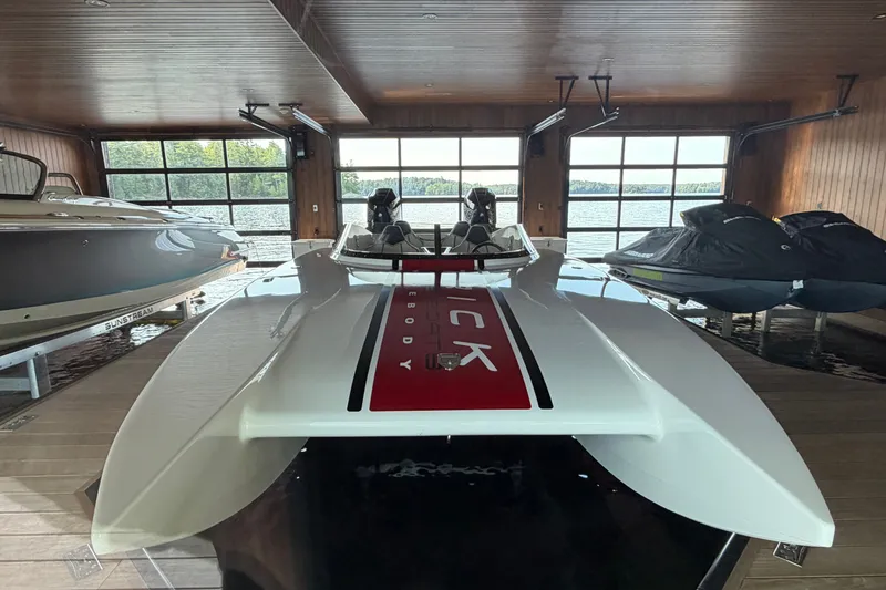 Slide: The Image of 2024 Trick 23 Widebody boat in a wooden boathouse with lake view. - 4