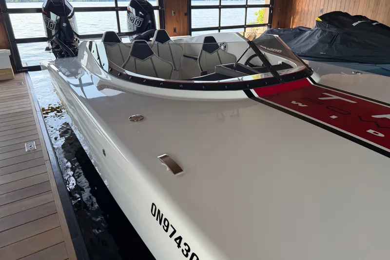 Slide: The Image of 2024 Trick 23 Widebody boat docked indoors, featuring sleek design and dual engines. - 21