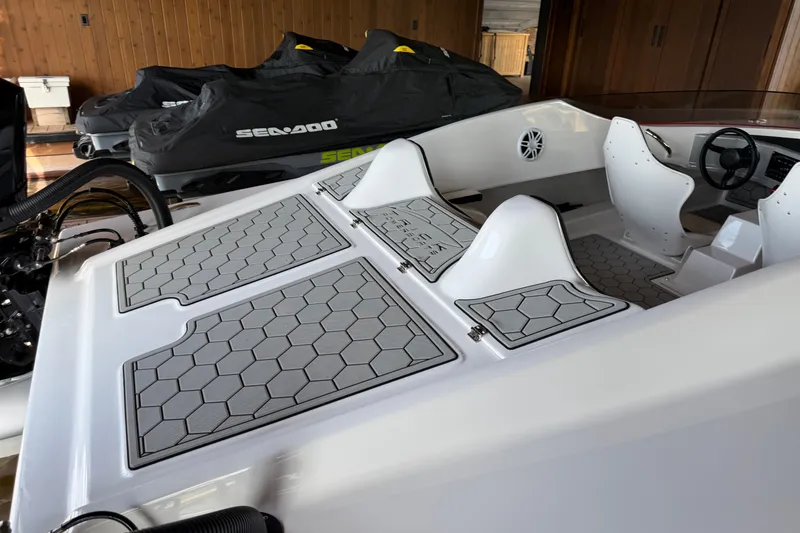 Slide: The Image of 2024 Trick 23 Widebody boat interior with hexagonal pattern flooring and sleek white seating. - 9
