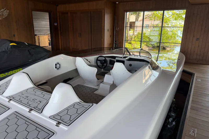 Slide: The Image of 2024 Trick 23 Widebody boat in wooden boathouse with large window view. - 10