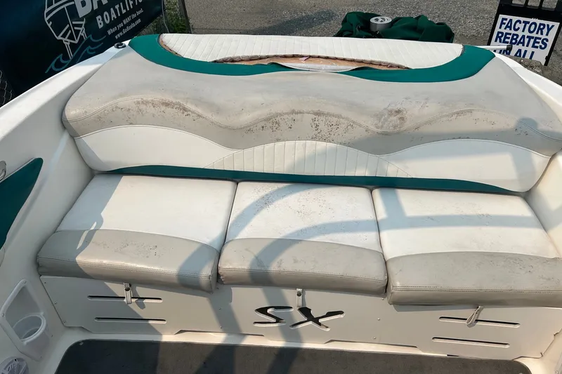 Slide: The Image of 2006 Glastron SX 195 boat interior with worn white and teal seating. - 12