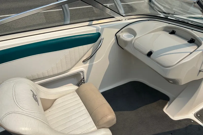 Slide: The Image of 2006 Glastron SX 195 boat interior with white seating and teal accents. - 7