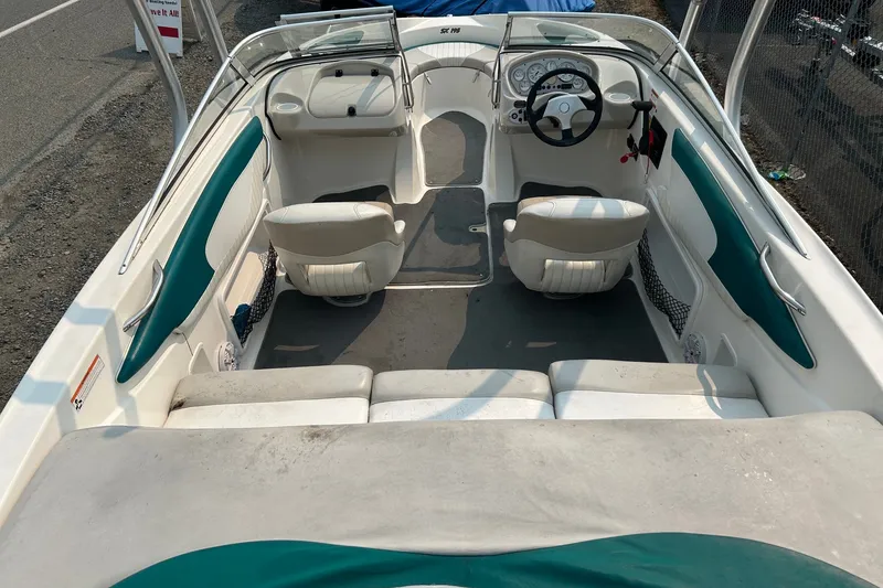 Slide: The Image of 2006 Glastron SX 195 boat interior with white and teal seating, steering wheel, and dashboard. - 11
