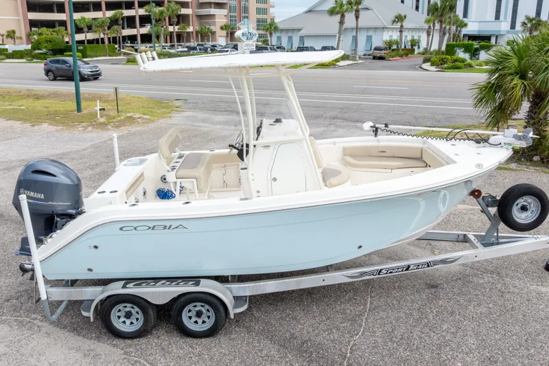 Slide: The Image of 2016 Cobia 201 Center Console boat on trailer, parked near road. - 2