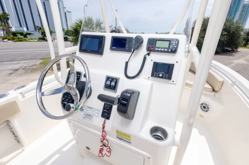 Slide: The Image of 2016 Cobia 201 Center Console boat dashboard with steering wheel and navigation equipment. - 26