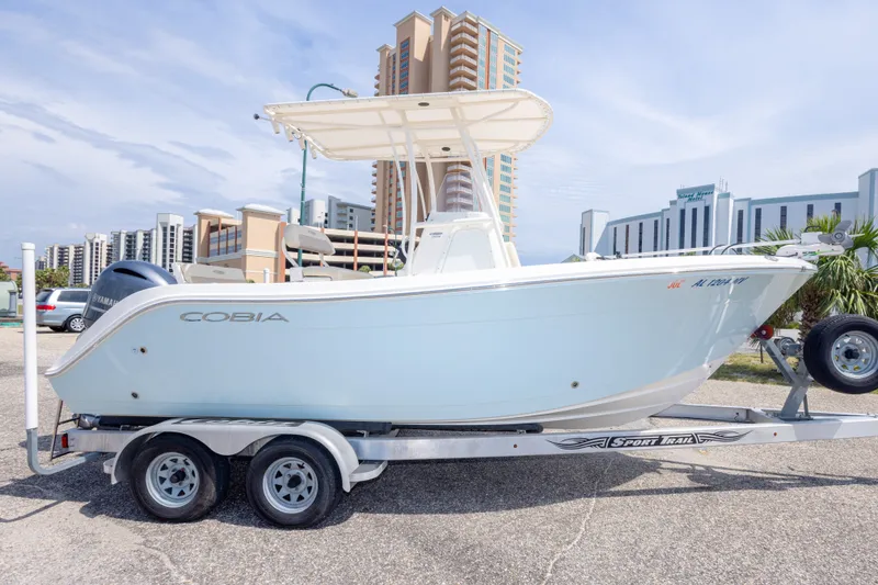 Slide: The Image of 2016 Cobia 201 Center Console boat on trailer, urban background, clear sky. - 12
