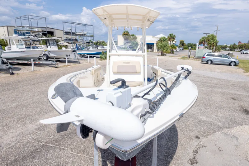 Slide: The Image of 2016 Cobia 201 Center Console boat with trolling motor in a marina setting. - 19