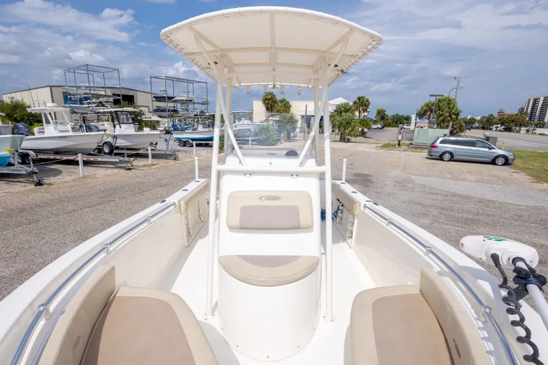 Slide: The Image of 2016 Cobia 201 Center Console boat with seating, parked in a marina lot. - 33
