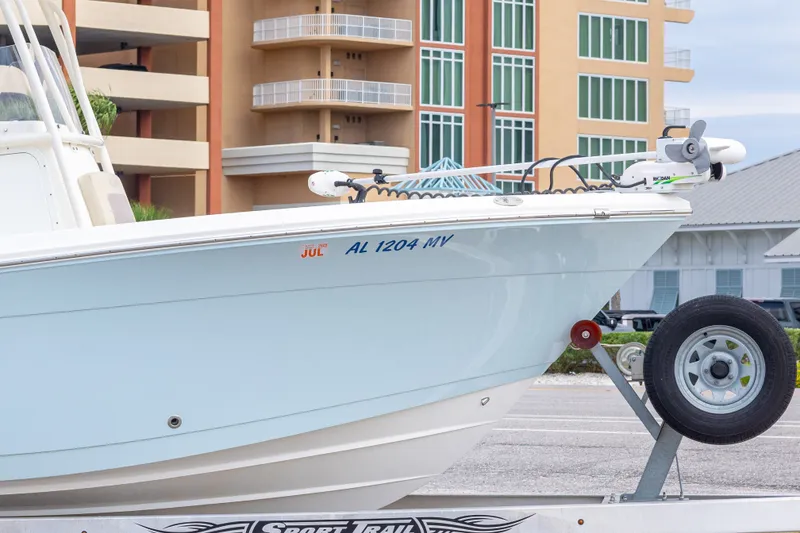 Slide: The Image of 2016 Cobia 201 Center Console boat on trailer, parked near buildings. - 10
