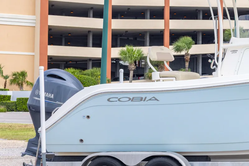 Slide: The Image of 2016 Cobia 201 Center Console boat with Yamaha engine, parked near a building. - 9