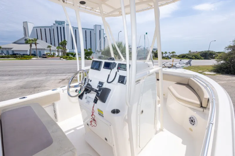 Slide: The Image of 2016 Cobia 201 Center Console boat parked near a coastal road. - 25