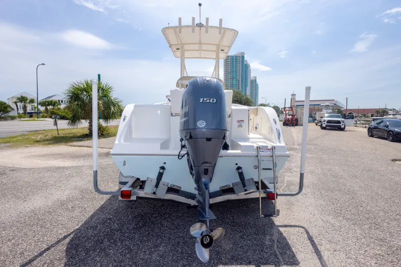 Slide: The Image of 2016 Cobia 201 Center Console boat with Yamaha 150 engine, parked outdoors. - 14
