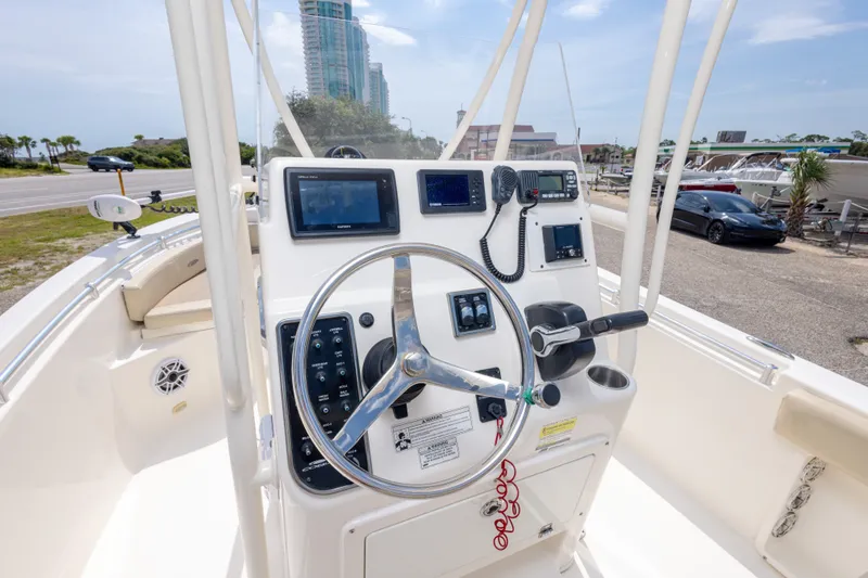 Slide: The Image of 2016 Cobia 201 Center Console boat dashboard with steering wheel and navigation equipment. - 27