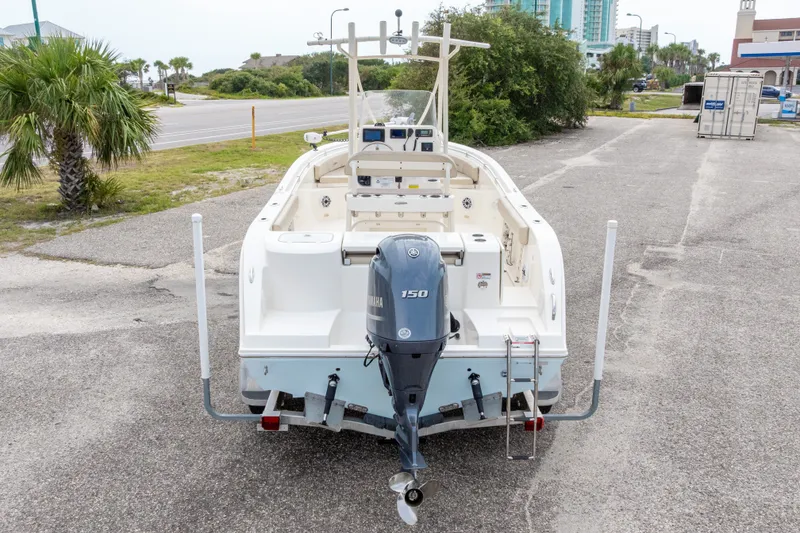 Slide: The Image of 2016 Cobia 201 Center Console boat with Yamaha 150 engine, parked near palm trees. - 50