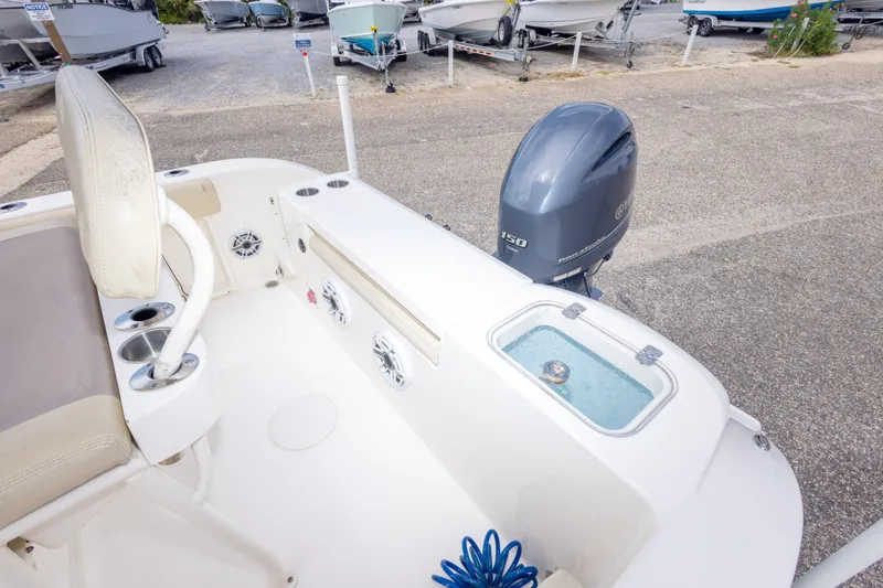 Slide: The Image of 2016 Cobia 201 Center Console boat with Yamaha 150 engine, docked on gravel. - 44