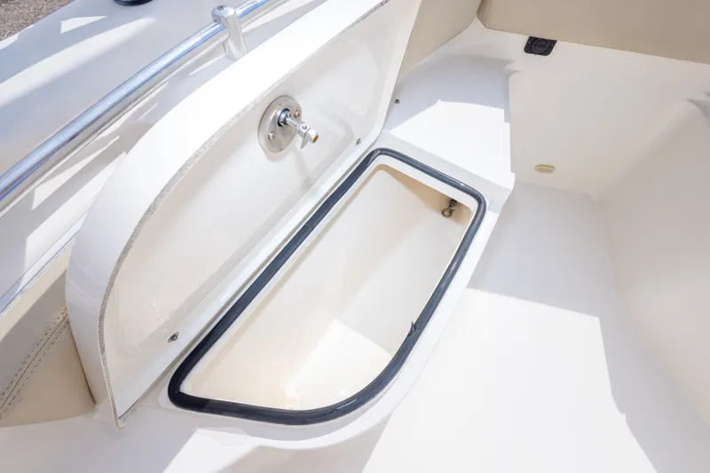 Slide: The Image of 2016 Cobia 201 Center Console boat storage compartment, open and empty. - 35