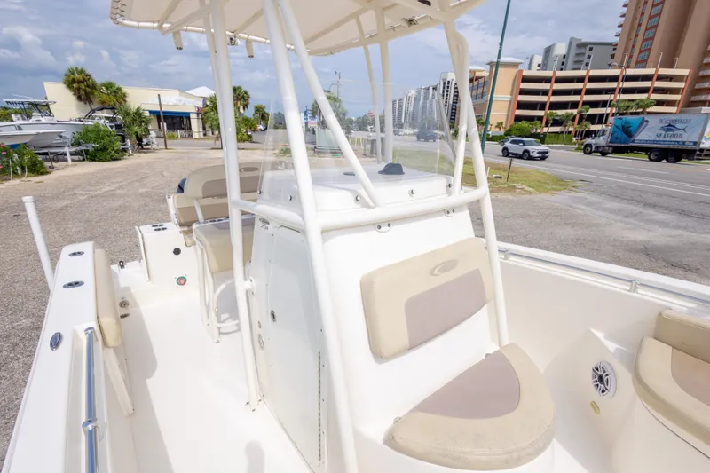 Slide: The Image of 2016 Cobia 201 Center Console boat parked near a road with buildings in the background. - 38