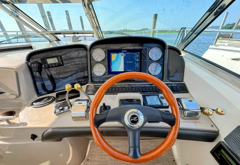 Slide: The Image of The 2005 Sea Ray 390 Sundancer cockpit features a sleek wooden steering wheel and modern instruments. - 12