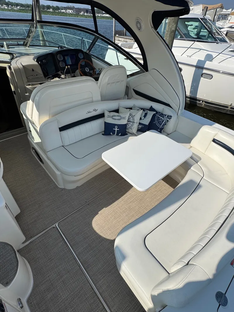 Slide: The Image of The image shows the cockpit of a 2005 Sea Ray 390 Sundancer with white leather seating and a table. - 20