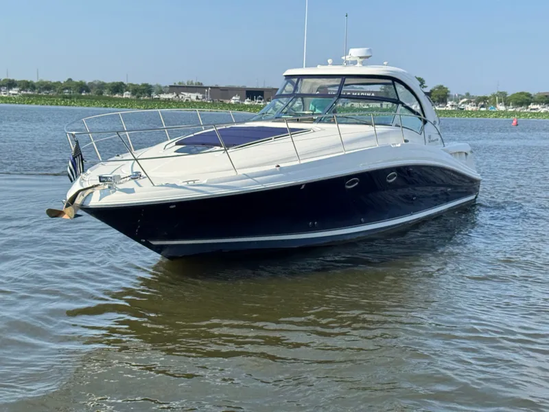 Slide: The Image of A 2005 Sea Ray 390 Sundancer cruising on calm water. It features a sleek, modern design. - 4