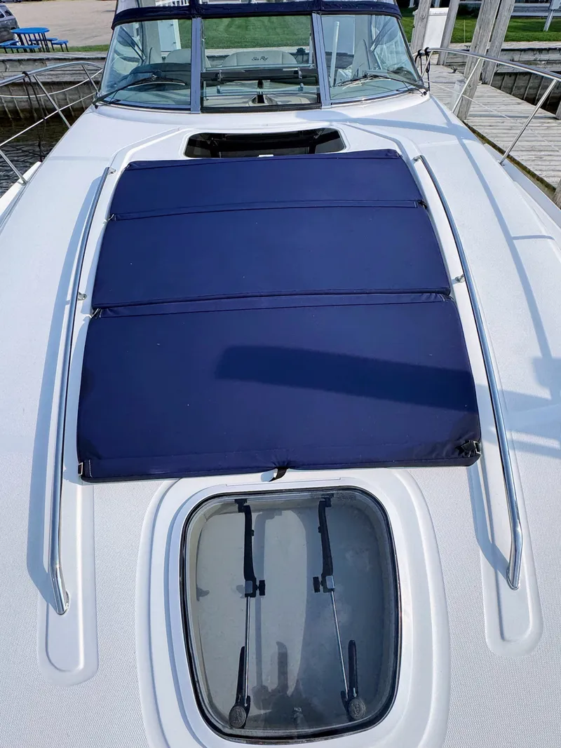 Slide: The Image of The image shows the foredeck of a 2005 Sea Ray 390 Sundancer with blue cushions. - 9
