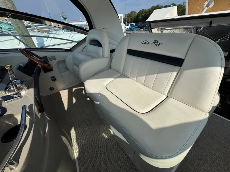Slide: The Image of The image shows the cockpit of a 2005 Sea Ray 390 Sundancer with white leather seating. - 32