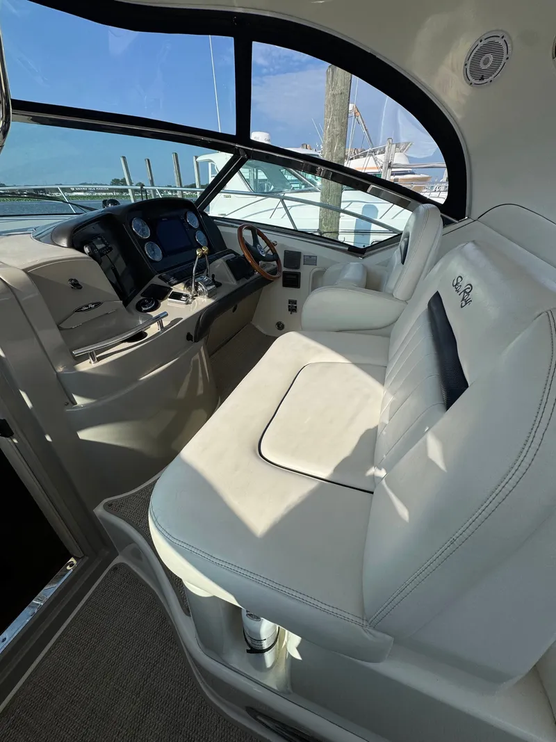 Slide: The Image of The cockpit of the 2005 Sea Ray 390 Sundancer features white leather seating and a modern dashboard. - 34