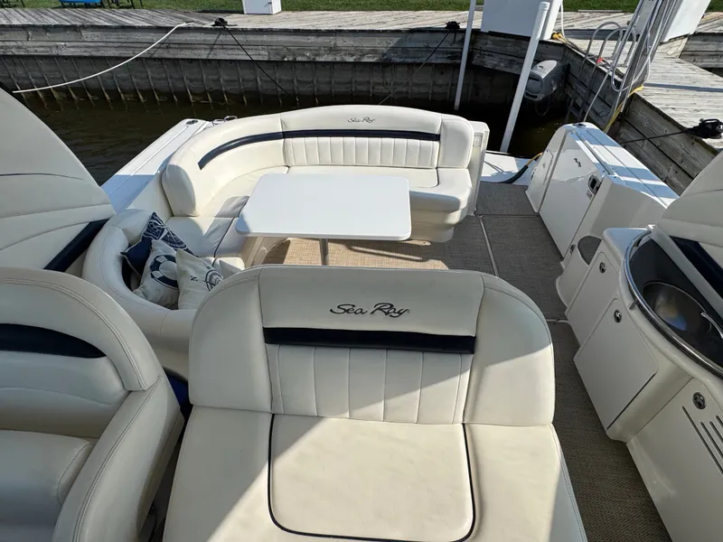 Slide: The Image of The image shows the cockpit of a 2005 Sea Ray 390 Sundancer with beige seating and a table. - 23