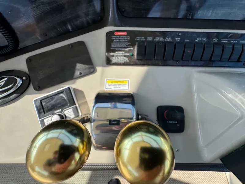 Slide: The Image of Close-up of the helm of a 2005 Sea Ray 390 Sundancer with gold throttle levers. - 16