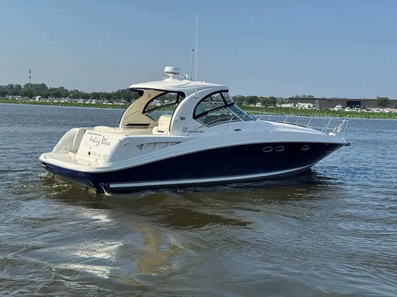 Slide: The Image of A 2005 Sea Ray 390 Sundancer cruising on calm waters. It features a sleek design. - 1