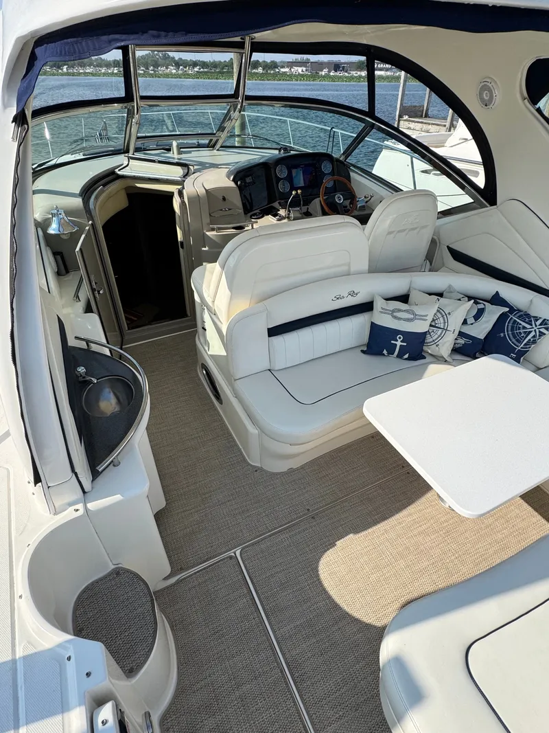 Slide: The Image of The image shows the cockpit of a 2005 Sea Ray 390 Sundancer with white seating and a table. - 21
