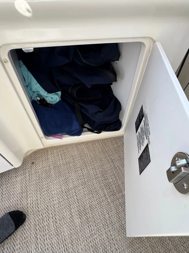 Slide: The Image of An open storage compartment on a boat with towels and clothing. - 26