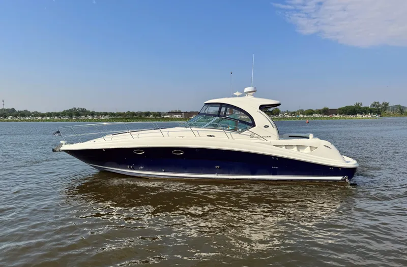 The Image of A 2005 Sea Ray 390 Sundancer on calm water, featuring sleek design and a blue hull. - 0
