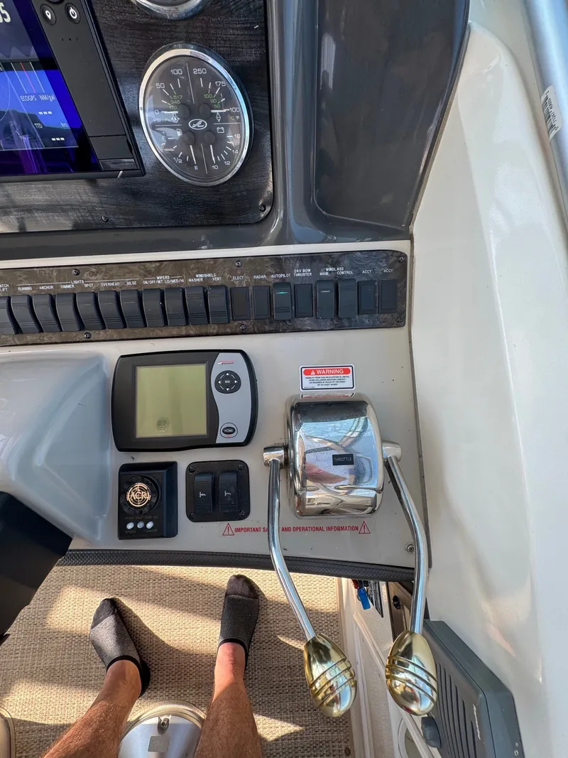 Slide: The Image of The image shows the helm of a 2005 Sea Ray 390 Sundancer with instruments and throttle controls. - 15
