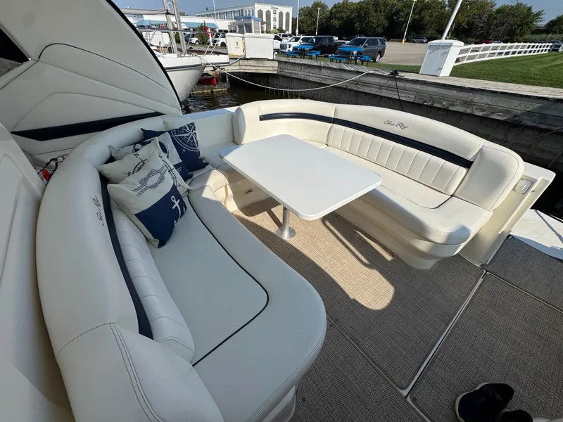 Slide: The Image of The 2005 Sea Ray 390 Sundancer features an elegant seating area with white upholstery and a table. - 22