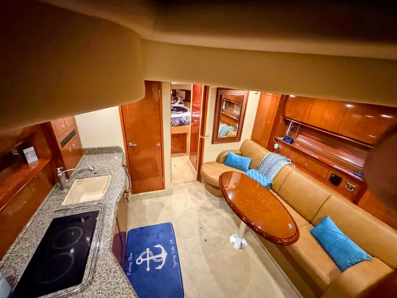 Slide: The Image of Interior of a 2005 Sea Ray 390 Sundancer with kitchen, sofa, and dining table. - 36