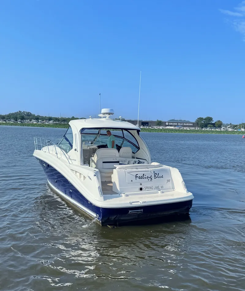 Slide: The Image of A 2005 Sea Ray 390 Sundancer cruising on calm waters. The name "Feeling's Blue" is visible on the stern. - 6