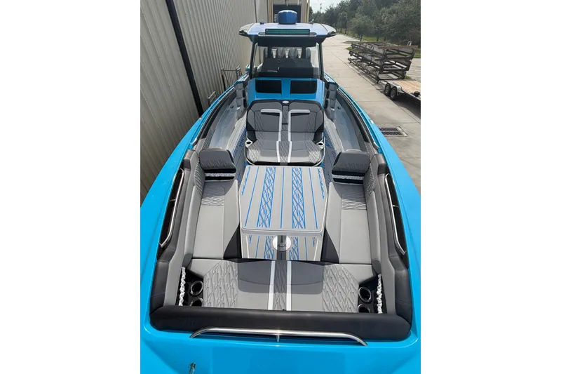 Slide: The Image of 2027 Nor-Tech boat with sleek blue and gray seating, docked outdoors. - 27