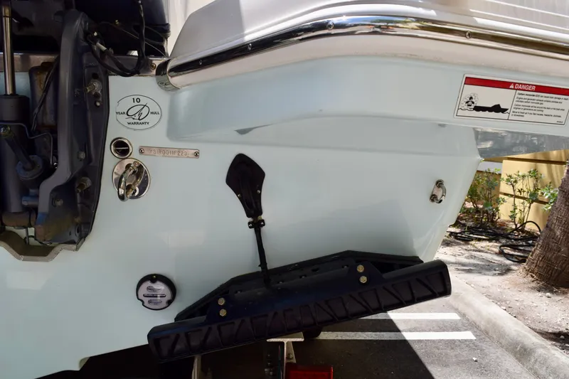 Slide: The Image of 2023 Sailfish 312 CC boat stern with warranty label and engine details. - 21