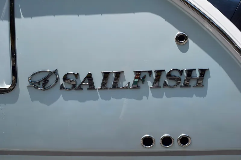 Slide: The Image of Chrome "Sailfish" logo on 2023 Sailfish 312 CC boat hull. - 23