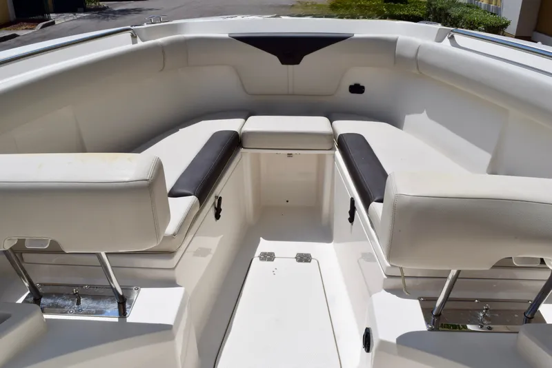 Slide: The Image of 2023 Sailfish 312 CC boat interior with white cushioned seating and storage compartments. - 16