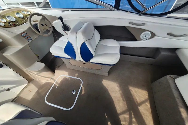 Slide: The Image of Interior of a 2017 Bayliner 210 Cuddy boat, featuring a steering wheel and cushioned seating. - 12
